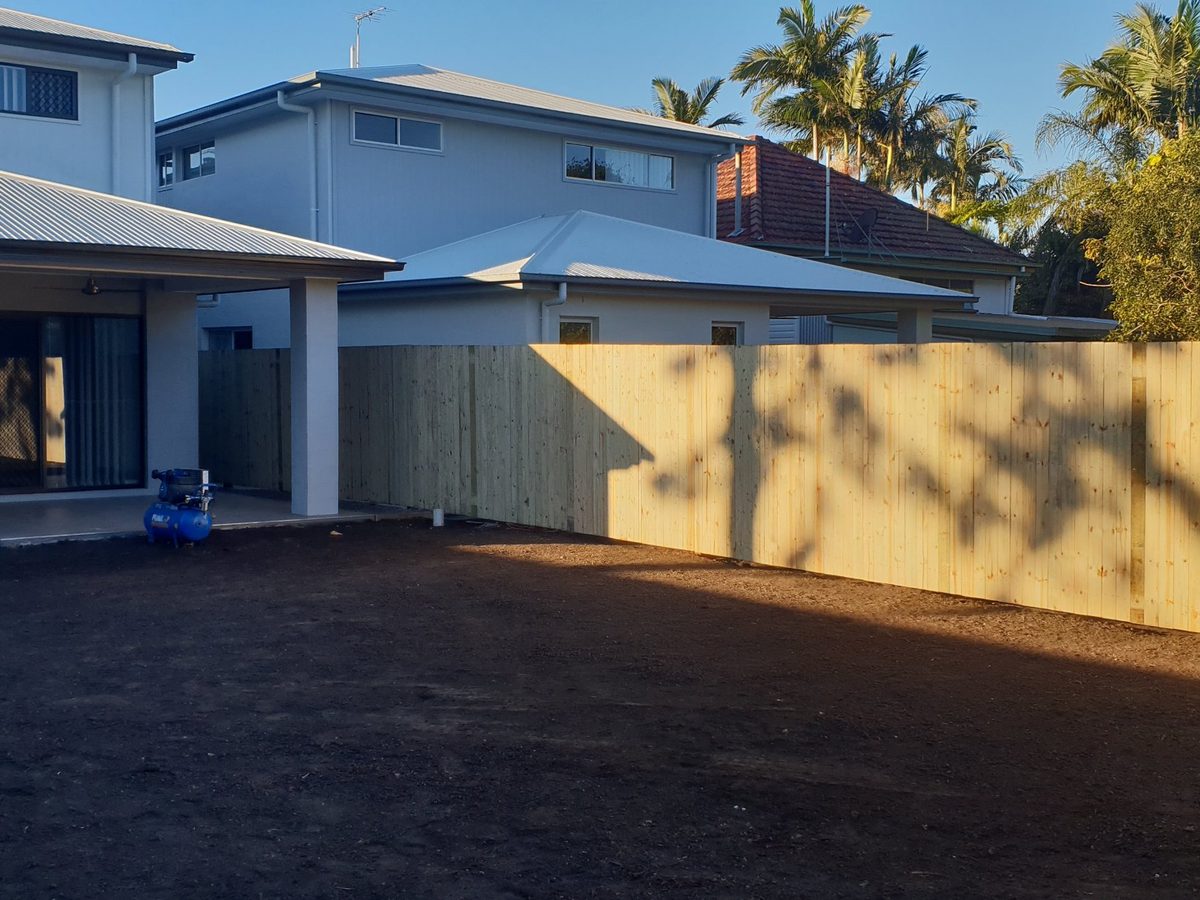 Yard graded and prepared alongside new fencing